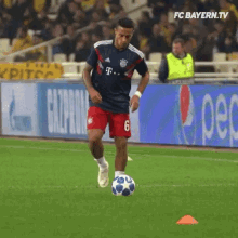 person dribbling soccer ball and doing moves around cones